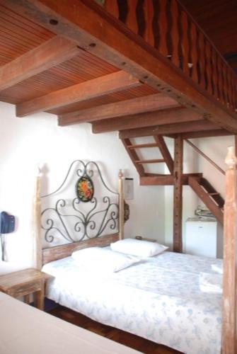 a bedroom with a large wooden bed with a wooden ladder at Pouso das Gerais in Tiradentes