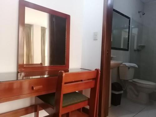 y baño con lavabo, espejo y aseo. en Room in Guest room - Amazing Junior Suite Close The Airport And Trade Center, en Bogotá
