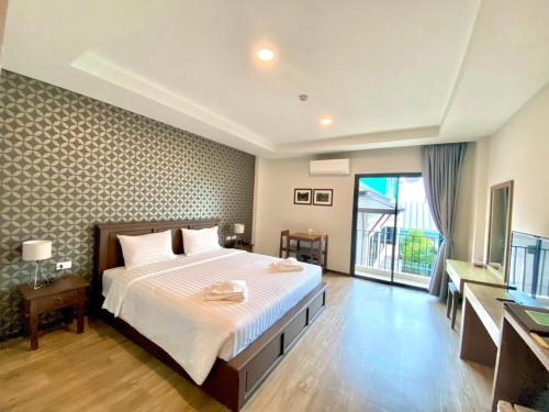 a bedroom with a large bed and a large window at J.P.GRAND HOTEL in Trat