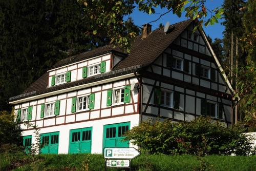 a house with green shutters and a brown roof at Bergische Schweiz in Engelskirchen