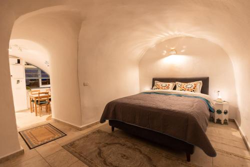 1 dormitorio con 1 cama y comedor en פינה שקטה בראש פינה העתיקה Pina Shketa in old Rosh-Pina, en Rosh Pina