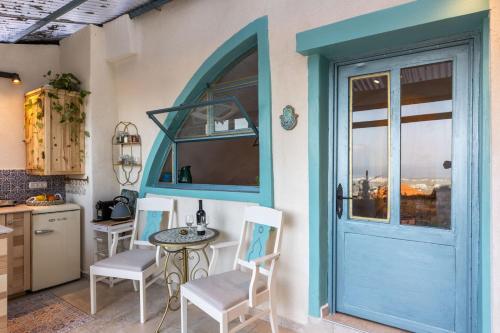 a kitchen with a blue door and a table and chairs at פינה שקטה בראש פינה העתיקה Quite Corner in old Rosh-Pina in Rosh Pinna
