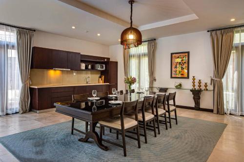 a kitchen and dining room with a table and chairs at Da Nang Paradise Center My Khe Beach Resort & Spa in Da Nang