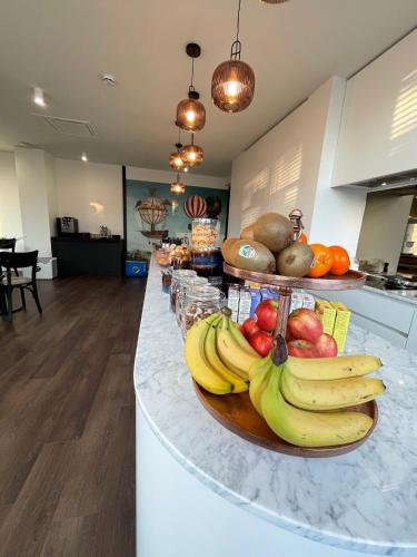 a plate of fruit on a counter in a kitchen at Hotel Bell-X Kortrijk-Wevelgem in Wevelgem