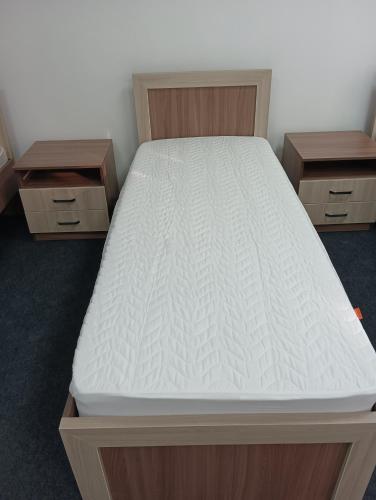 a bed in a room with two drawers at BekBro Hostel in Bishkek