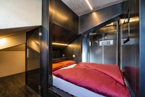 1 dormitorio con 1 litera con sábanas rojas en Loft on 1236, en Ortisei