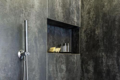 a shower stall with a shelf with books on it at Loft on 1236 in Ortisei