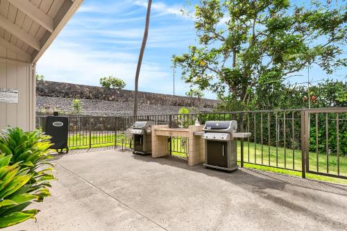 a patio with a grill and a fence at Casa Tropical Kona in Kailua-Kona