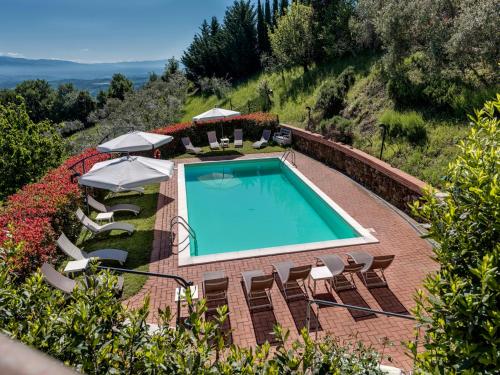 uma piscina exterior com cadeiras e guarda-sóis em Amoliv em Arezzo
