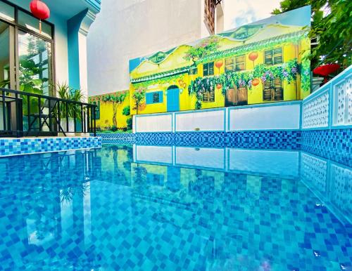 a swimming pool in front of a building at Grand Holiday Hoian Villa in Hoi An