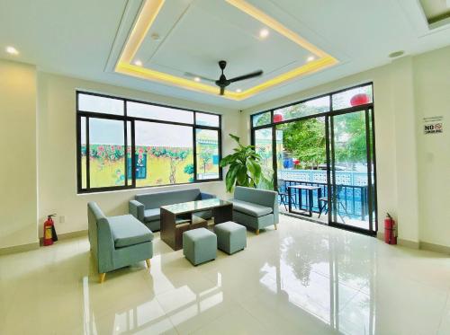 a living room with a couch and chairs and windows at Grand Holiday Hoian Villa in Hoi An