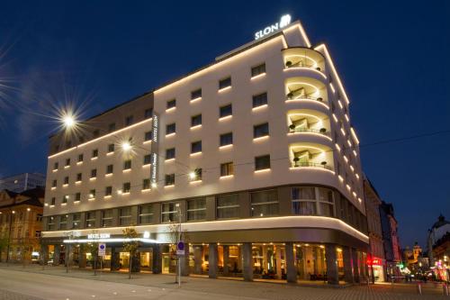a lit up building on a street at night at Best Western Premier Hotel Slon in Ljubljana