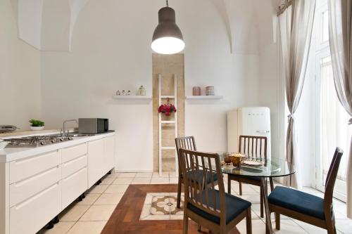 uma cozinha com uma mesa e cadeiras e um frigorífico em Xenia Old Town - Lecce Selection em Lecce