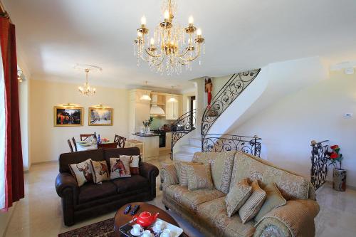 a living room with two couches and a chandelier at Le Petit Palais Villa in Plesio