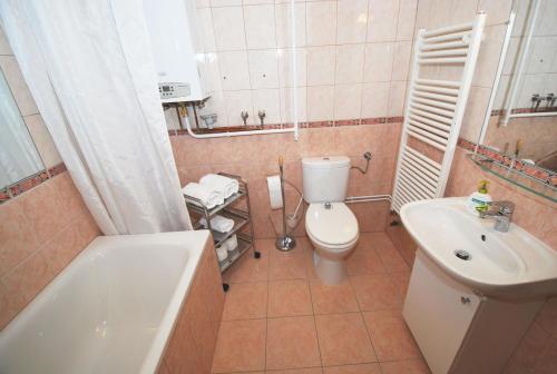 a bathroom with a toilet and a sink and a tub at Arpad Bridge Apartments in Budapest
