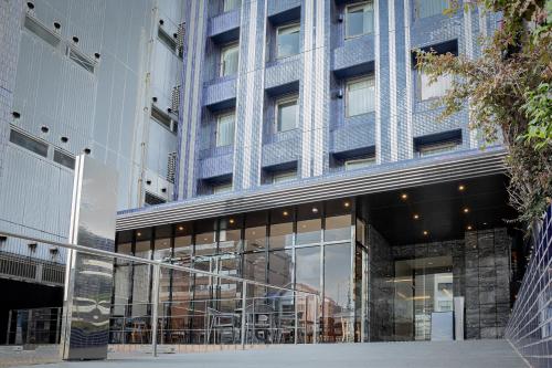 duży budynek ze szklanym wejściem do niego w obiekcie The BREAKFAST HOTEL Fukuoka Nakasu w mieście Fukuoka