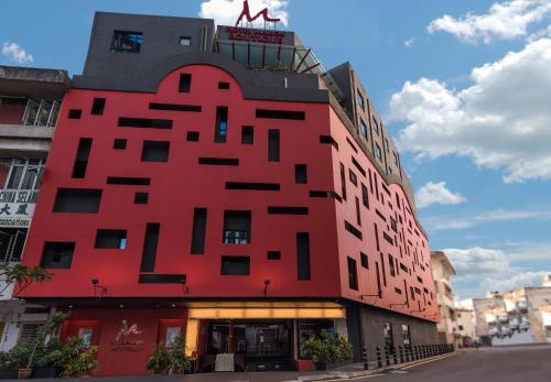 a red building with a sign on top of it at Maison Boutique Theme Hotel Kuala Lumpur by Swing & Pillows in Kuala Lumpur