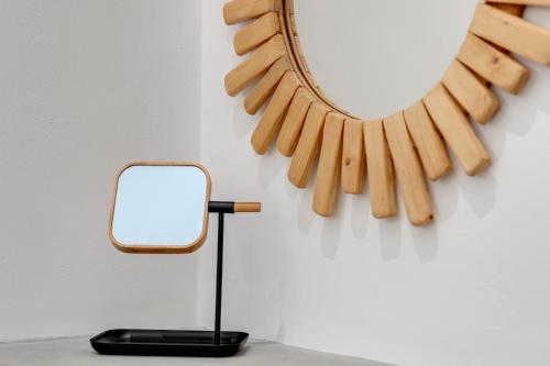 a mirror and a lamp next to a wall at SyRose Suites in Ermoupoli