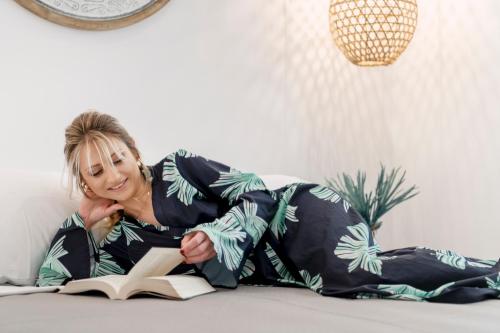 a woman laying on the floor reading a book at SyRose Suites in Ermoupoli