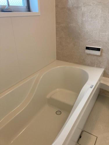 a white bath tub sitting in a bathroom at 森のカフェ in Beppu