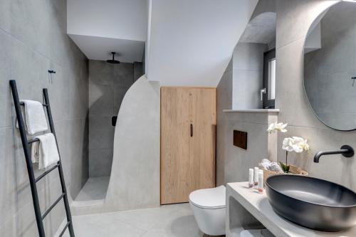 a bathroom with a sink and a toilet and a shower at SyRose Suites in Ermoupoli