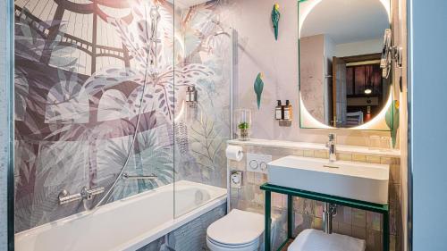 ein Badezimmer mit einem Waschbecken, einer Badewanne und einem WC in der Unterkunft Hotel Indigo Brussels - City, an IHG Hotel in Brüssel