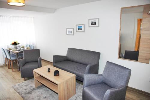 a living room with two chairs and a couch and a table at Ferienwohnungen Strandglück in Norddeich