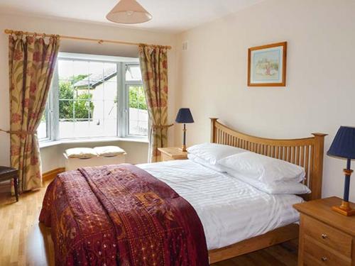 ein Schlafzimmer mit einem großen Bett und einem Fenster in der Unterkunft Lovers' Lodge in Kilkenny