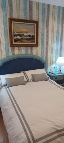 een slaapkamer met een bed met een blauw hoofdeinde bij Reyno de Baeza in Baeza