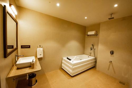 a bathroom with a sink and a bath tub at The Royal Palace Hotel 400703 in Navi Mumbai