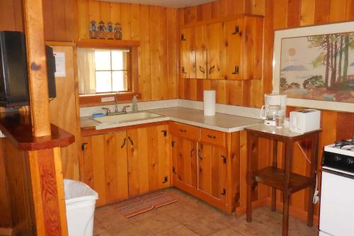 una cocina con armarios de madera y fregadero en Elkhorn Lodge en Chama