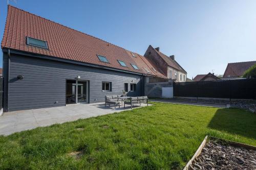 a backyard of a house with a grass yard at L'annexe Morbecque in Morbecque