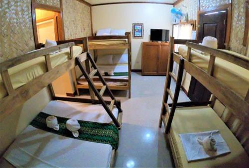 Zimmer mit 2 Etagenbetten in einem Zimmer in der Unterkunft Telesfora Beach Cottage in El Nido