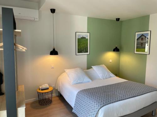a bedroom with a white bed and green walls at Hotel De Ma Tante in Lamalou-les-Bains