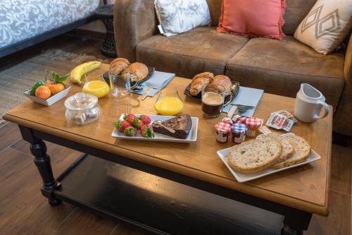 - une table basse avec des aliments pour le petit-déjeuner et des boissons dans l'établissement 6 place de la détente, à Saint-Venant