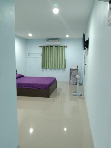 a room with a purple bed and a shower at OYO 75400 Moo Yim Resort in Rayong