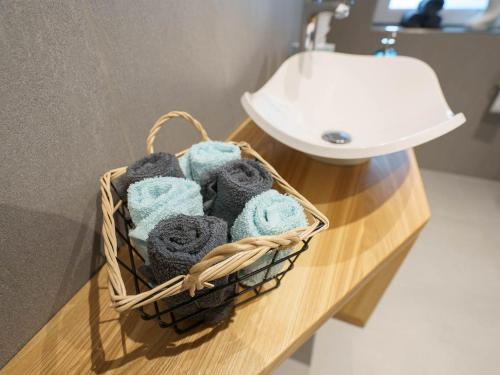 a basket of towels on a counter next to a sink at Ferienwohnung Hummel in Gammertingen