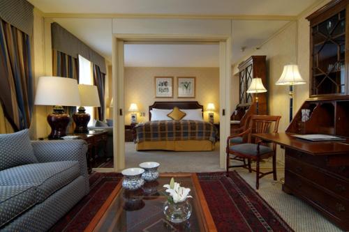 サンティアゴにあるパーク プラザ サンティアゴのベッドとリビングルームが備わるホテルルームです。