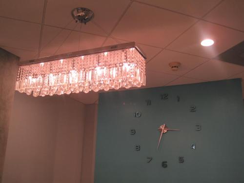 a large chandelier hanging from a ceiling with a clock at Miami Sun Hotel - Downtown/Port of Miami in Miami