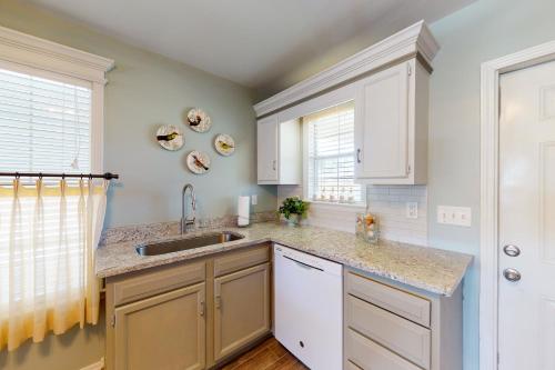 a kitchen with white cabinets and a sink at 21 Palms in Gulf Shores