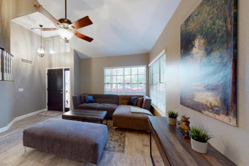 a living room with a couch and a ceiling fan at Luxe Lakewood Villa in Phoenix