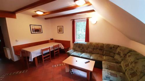 een woonkamer met een bank en een tafel bij Rogla Apartma Ostržek in Vitanje