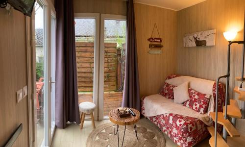 a small bedroom with a bed and a sliding glass door at Timaro in Bagnères-de-Bigorre