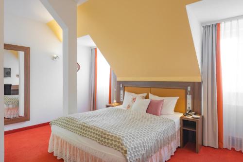 
a bedroom with a white bed and white walls at Hotel bei Tante ALMA in Mannheim
