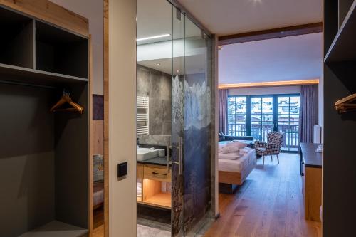 a room with a glass door leading to a bedroom at Hotel Jagdschlössl in Kirchdorf in Tirol