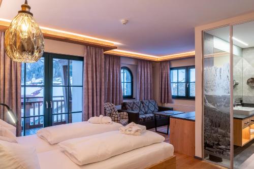 a bedroom with two beds and a living room at Hotel Jagdschlössl in Kirchdorf in Tirol