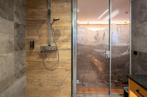 a shower with a glass door in a bathroom at Hotel Jagdschlössl in Kirchdorf in Tirol