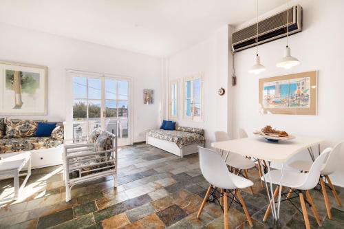 a living room with a table and chairs and a couch at Aeginia 2 in Perdika