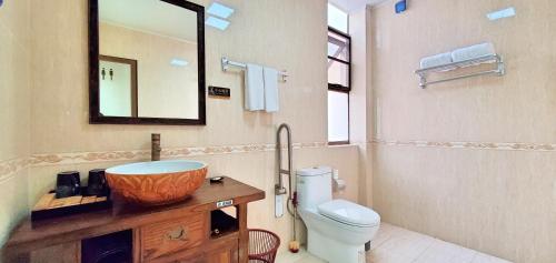 a bathroom with a sink and a toilet and a mirror at Sanya Haitangwan Shang Gong Yuan She Wellness Resort Villa in Sanya
