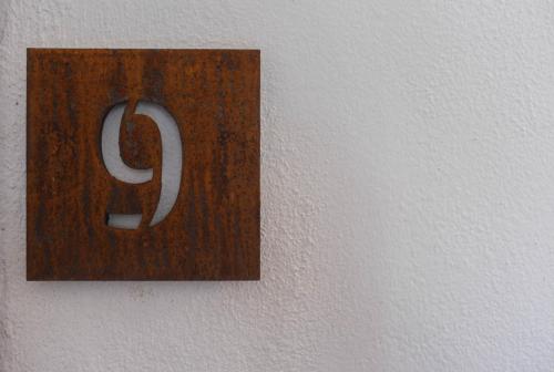 a wooden sign on a wall with the letter j at Hotel Cavour Et Des Officiers in Bard